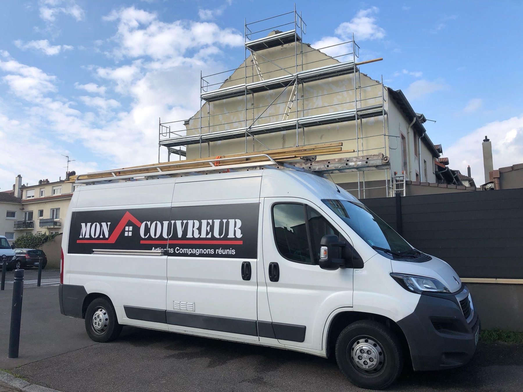 Le camion Mon Couvreur devant un pignon échafaudé